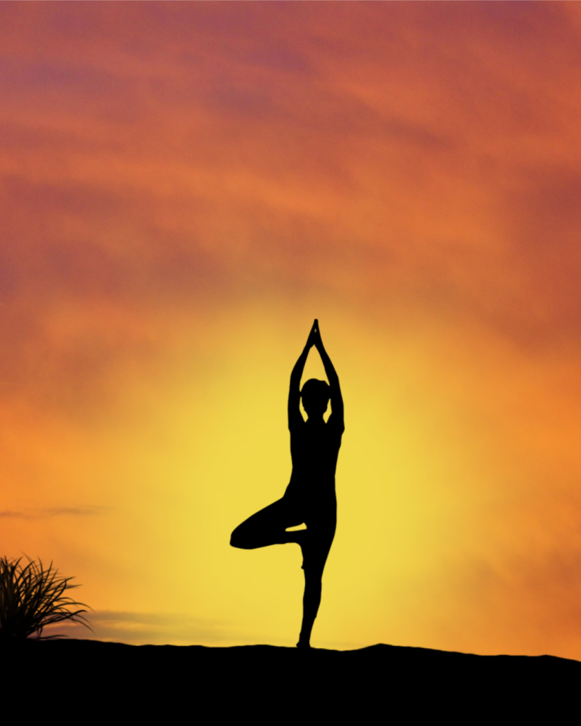 Woman doing yoga at sunset