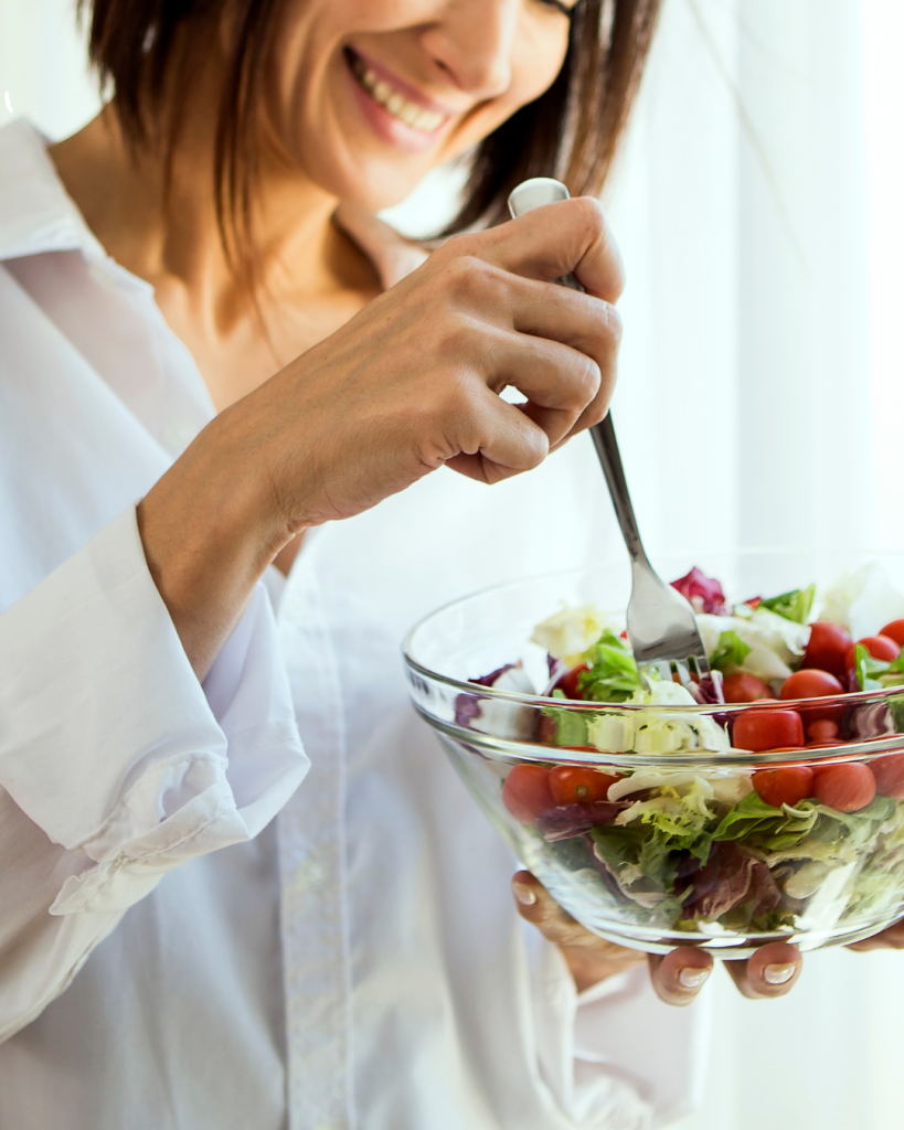 Woman eating a bowl of salad