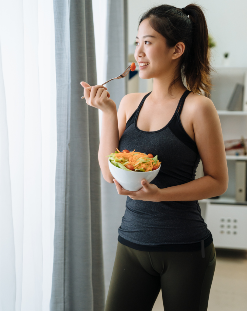Woman in workout gear eating salad