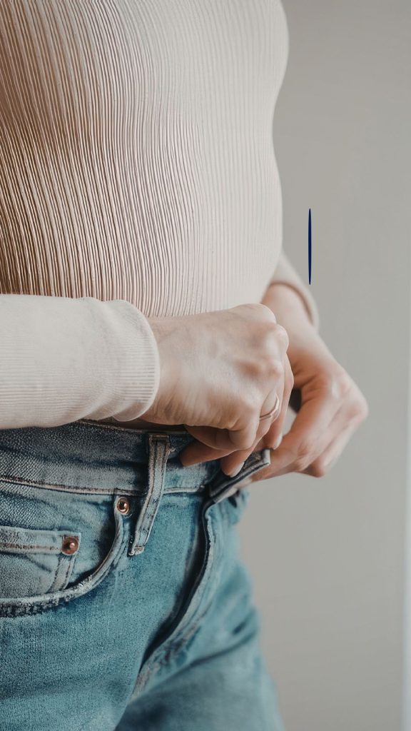 Woman doing up her jeans